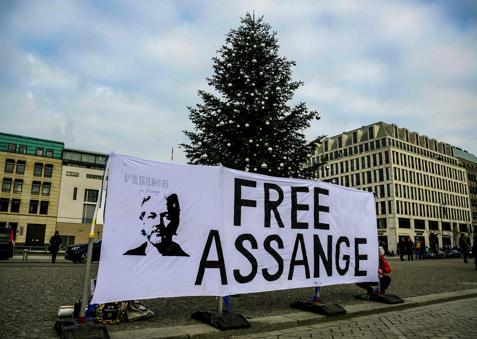 An activist puts up a banner reading "Free Assange" in …