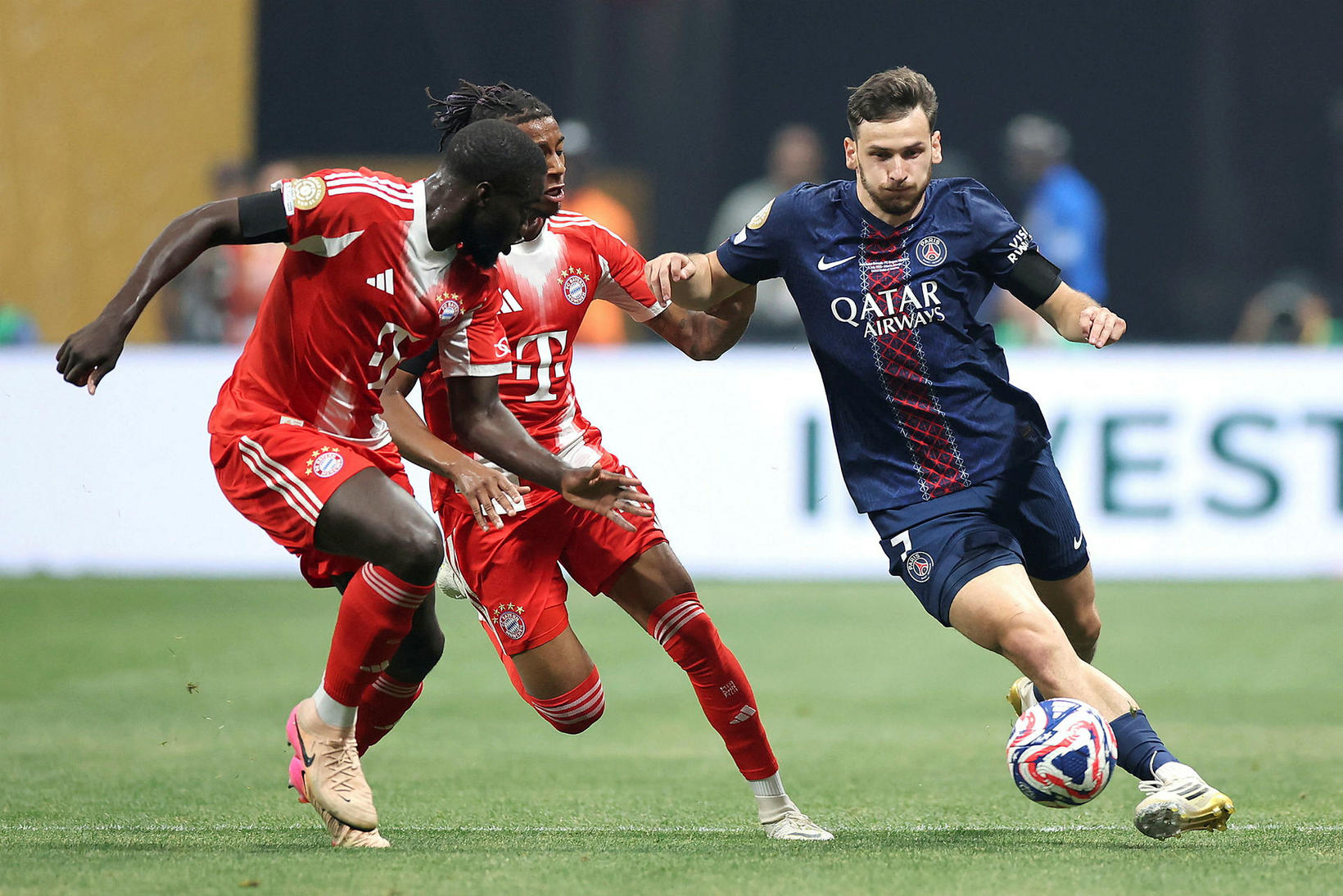 Khvicha Kvaratskhelia á boltanum en Bayern-mennirnir Dayot Upamecano og Michael …