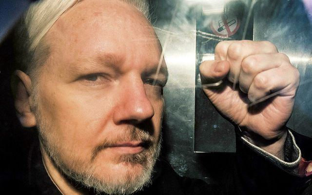 Julian Assange steytir hnefann um borð í fangaflutningabíl í London 1. maí síðastliðinn.