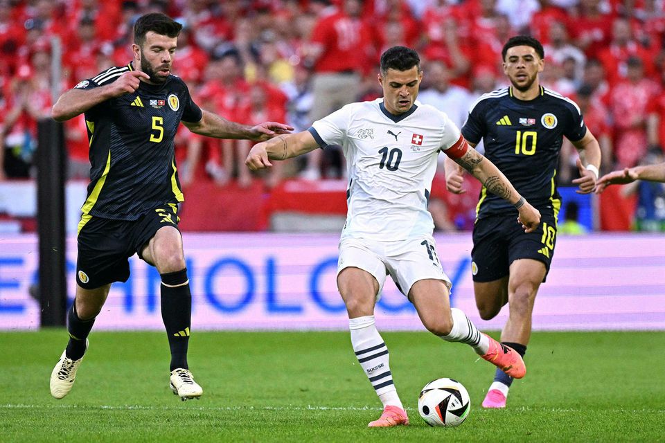 Granit Xhaka með boltann í leiknum undir pressu frá Grant Hanley og Che Adams.