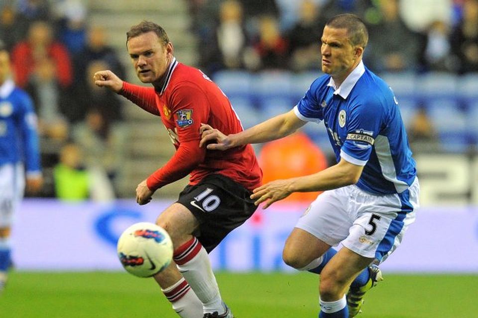 Wayne Rooney og Gary Caldwell eigast við í leik Wigan og Manchester United.