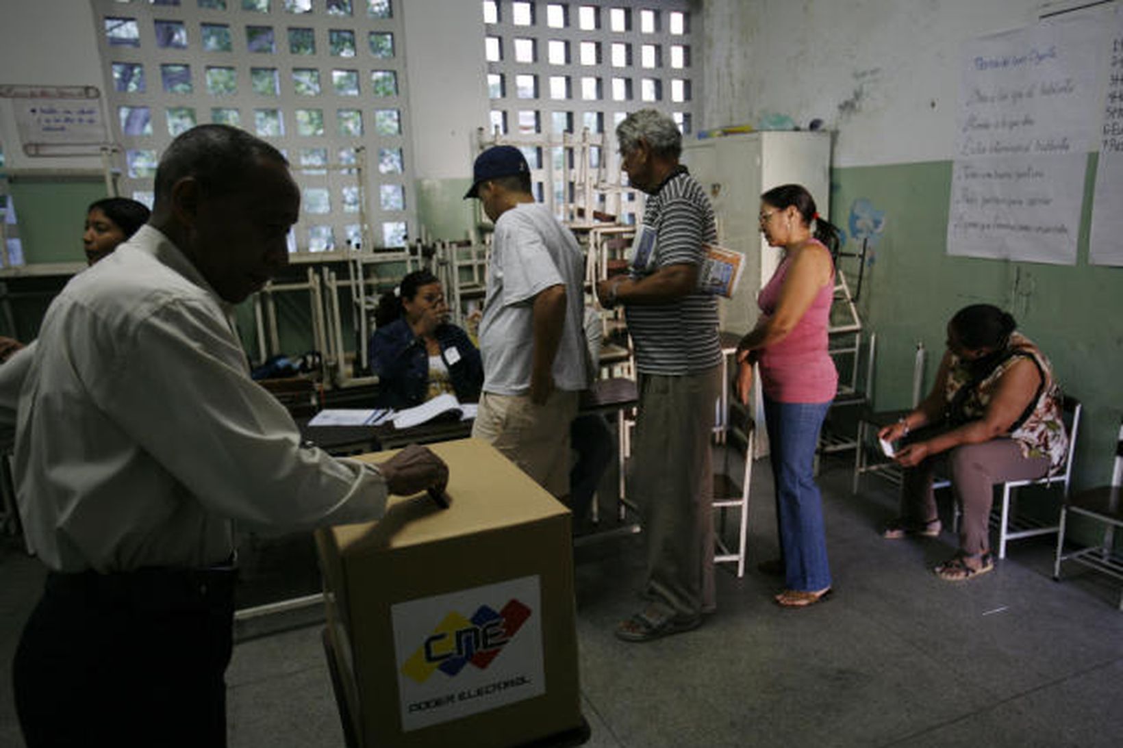 Íbúar í Venesúela sjást hér ganga að kjörborðinu í Caracas …