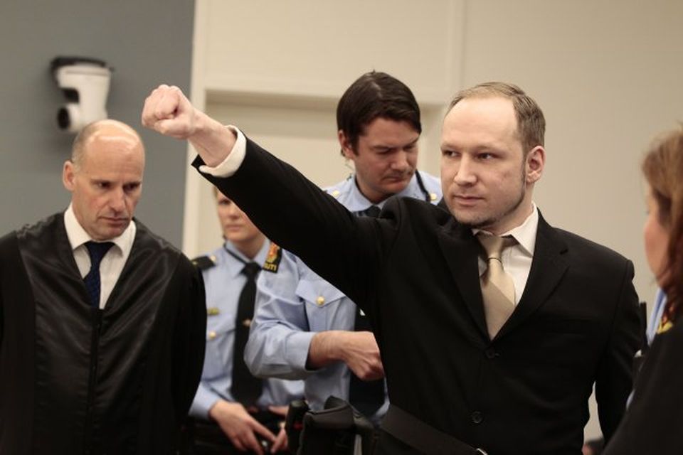 Anders Behring Breivik heilsar að fasistasið við komuna í réttarsalinn í morgun.