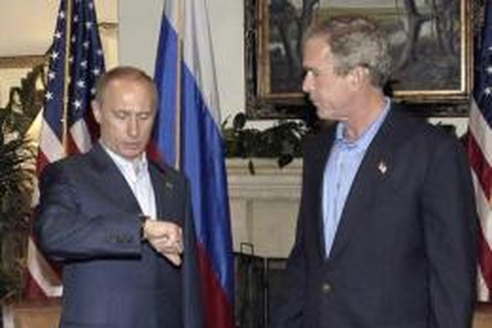 Vladímír Pútín lítur á klukkuna en George W. Bush horfir …