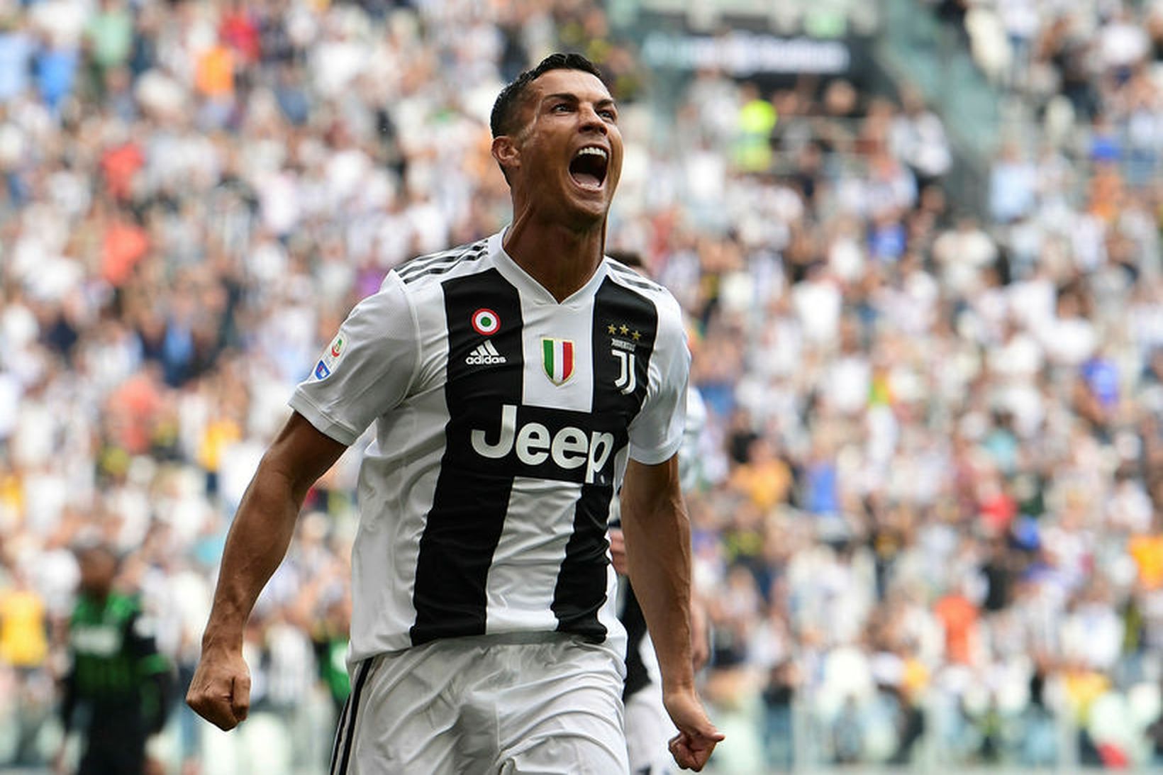 Cristiano Ronaldo fagnar marki í svörtum og hvítum búningi Juventus.