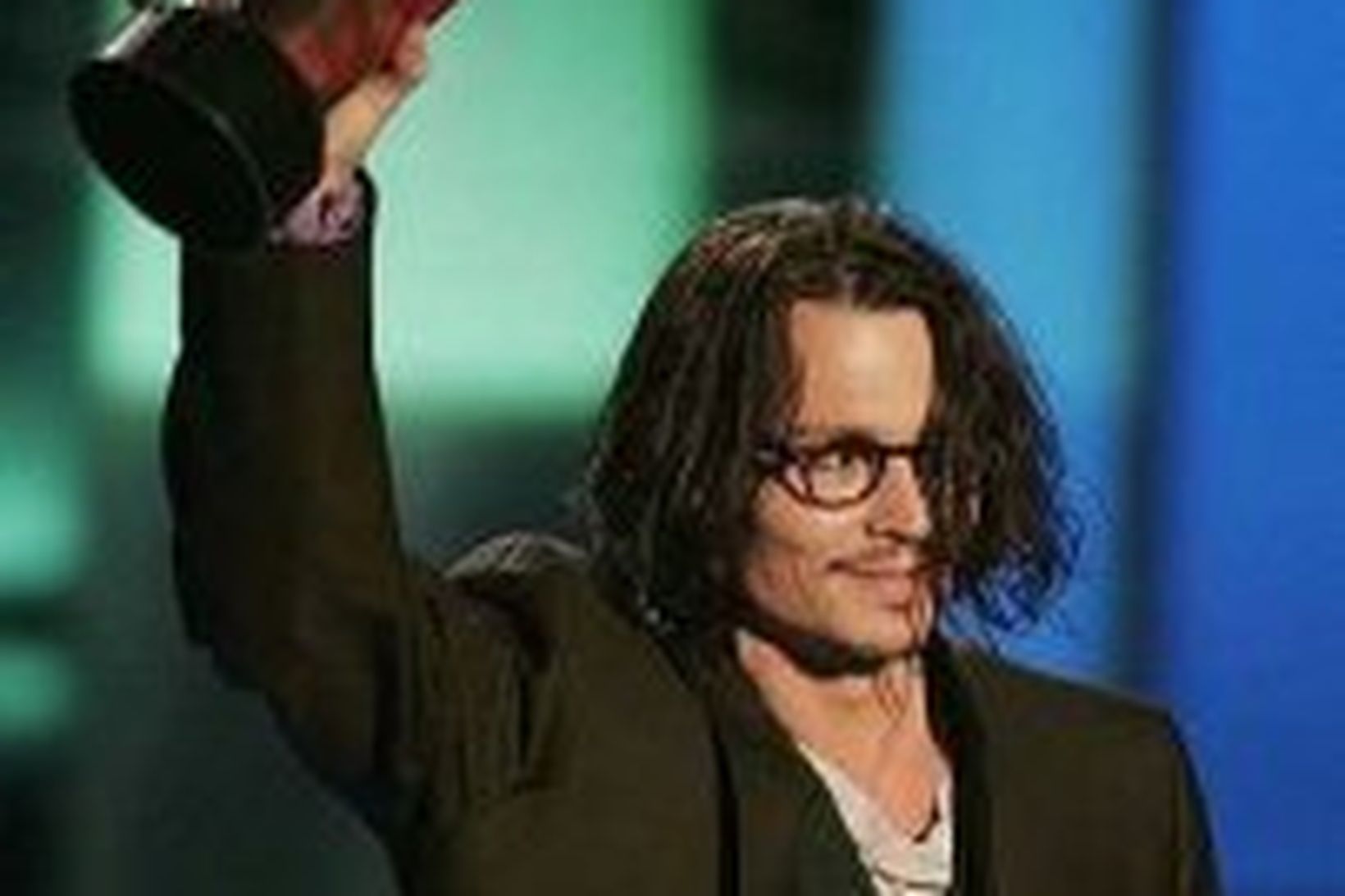 Johnny Depp brosir sínu blíðasta með verðlaunin.