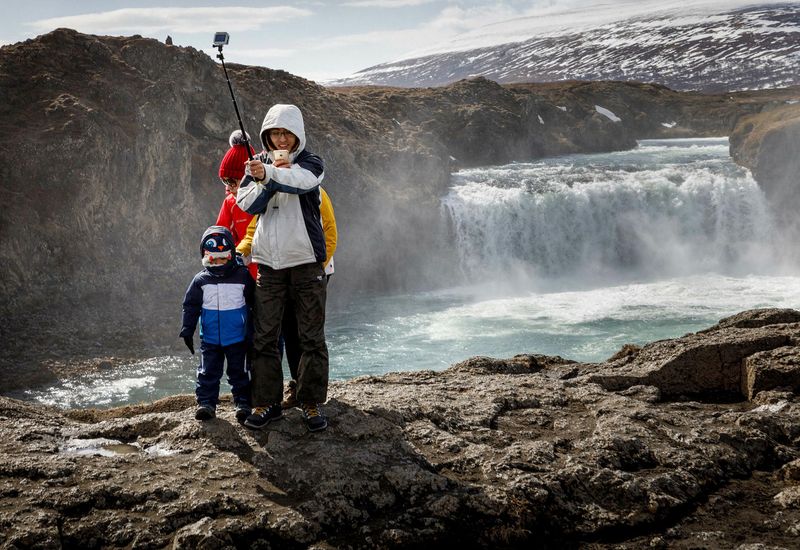 Tourists by Goðafoss waterfall, North Iceland.