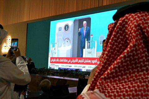 Almenningur fylgist með útsendingu frá komu Trumps til Sádí-Arabíu í dag.