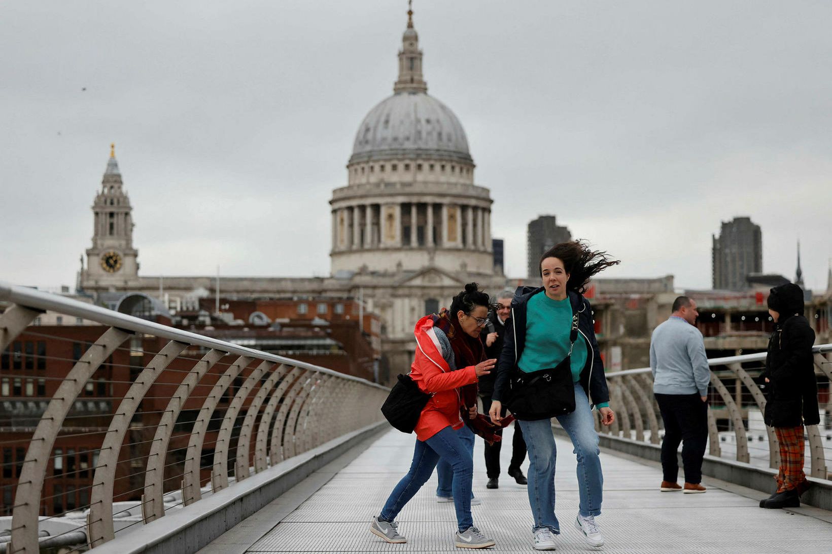 Fólk fýkur til og frá í London í dag.