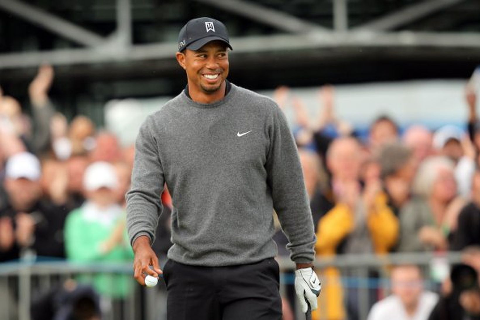 Tiger Woods leyfði sér að brosa á 18. flötinni í …