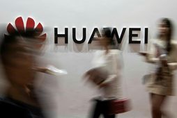 Fólk gengur fram hjá lógói Huawei í Peking í fyrra.