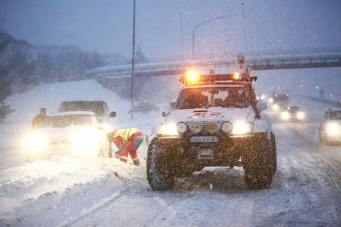 Rescue teams at work dislodging cars stuck in the snow.