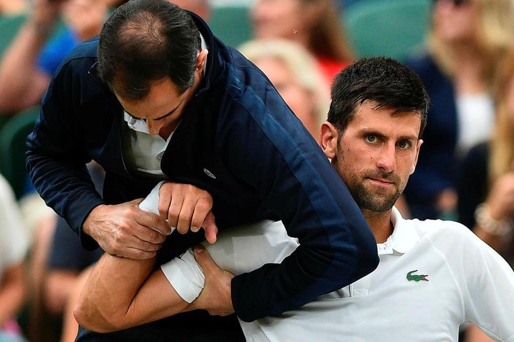 Novak Djokovic fær aðhlynningu á Wimbledon-mótinu.