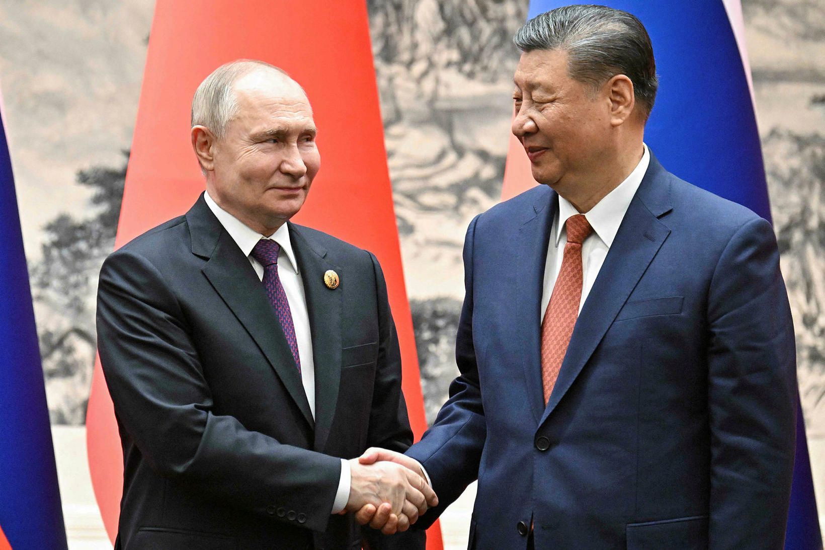 Pútín og Xi Jinping takast í hendur í morgun.