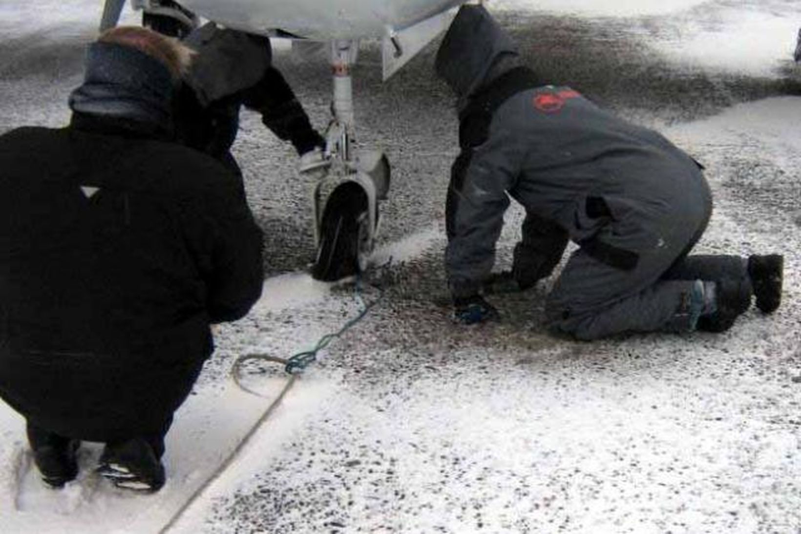 Flugvirkjar skoða nefhjólið sprungna.