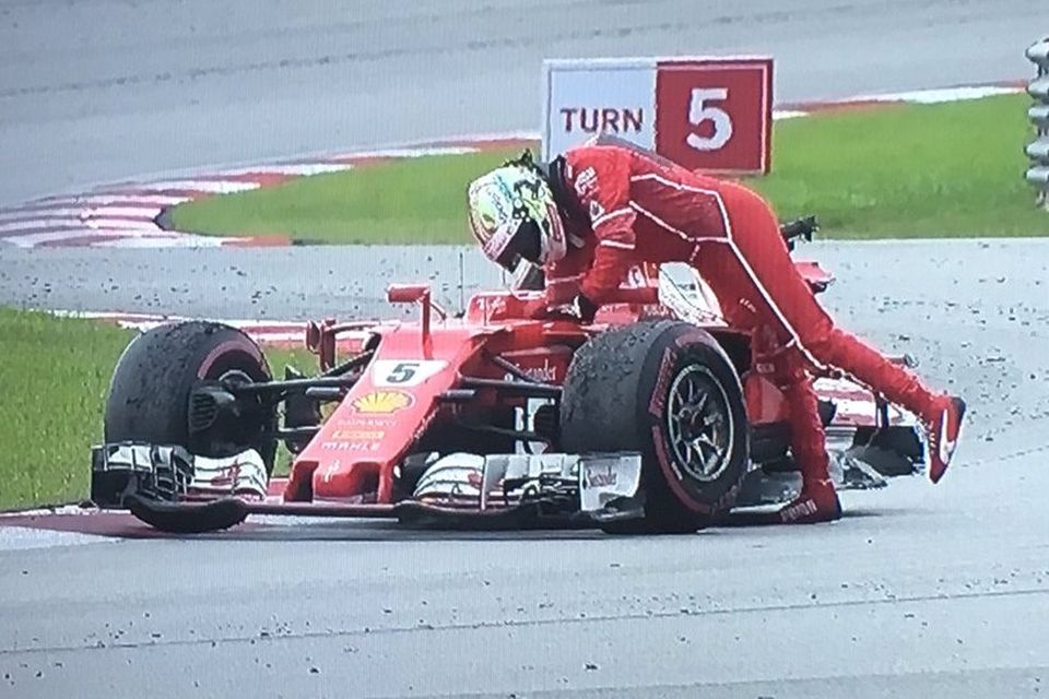 Vettel gengur frá Ferraribílnum eftir áreksturinn við Stroll á innhring í Sepang í Malasíu.
