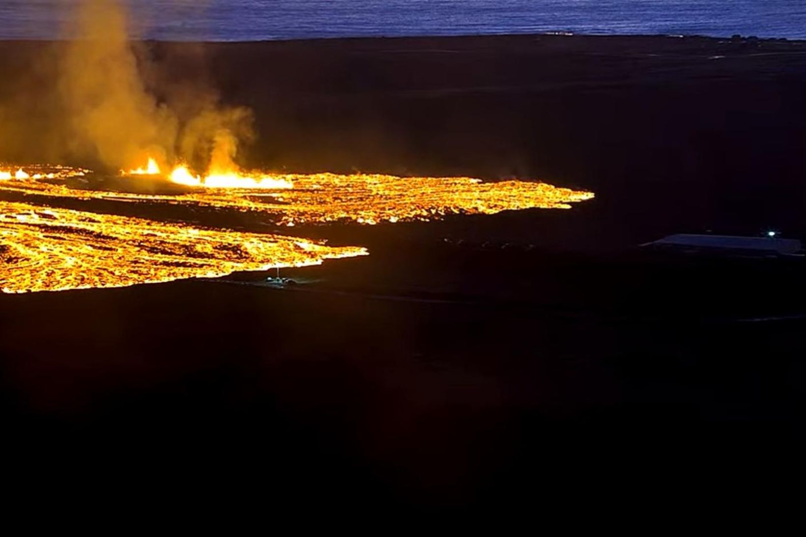 Hraunið rennur beggja vegna varnargarðsins. Unnið verður allan sólarhringinn við …