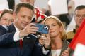 Naumt Rafal Trzaskowski, borgarstjóri Varsjár, tekur sjálfu af sér og konu sinni á sviðinu í kosningaherbúðum flokks síns í bænum Sandomierz eftir að ljóst var að hann hefði sigrað í fyrri umferð forsetakosninganna í Póllandi.