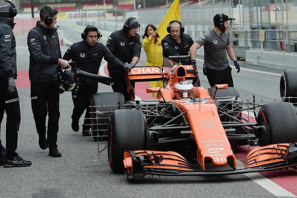 Vélvirkjar McLaren ýta Stoffel Vandoorme heim í bílskúr eftir bilun í Barcelona í dag.