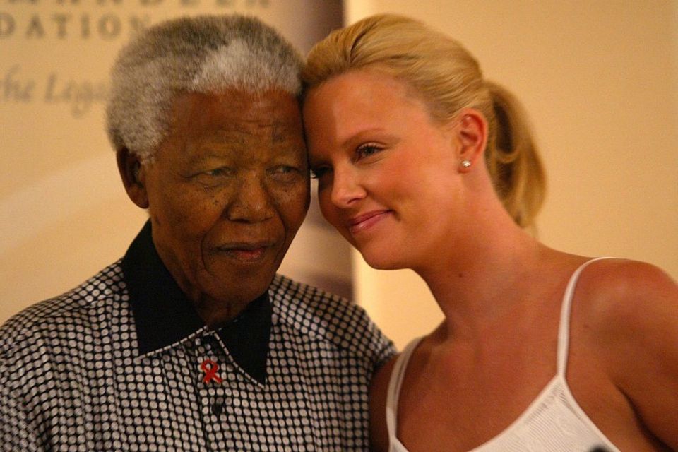 Mandela árið 2004 ásamt suður-afrísku leikkonunni Charlize Theron.