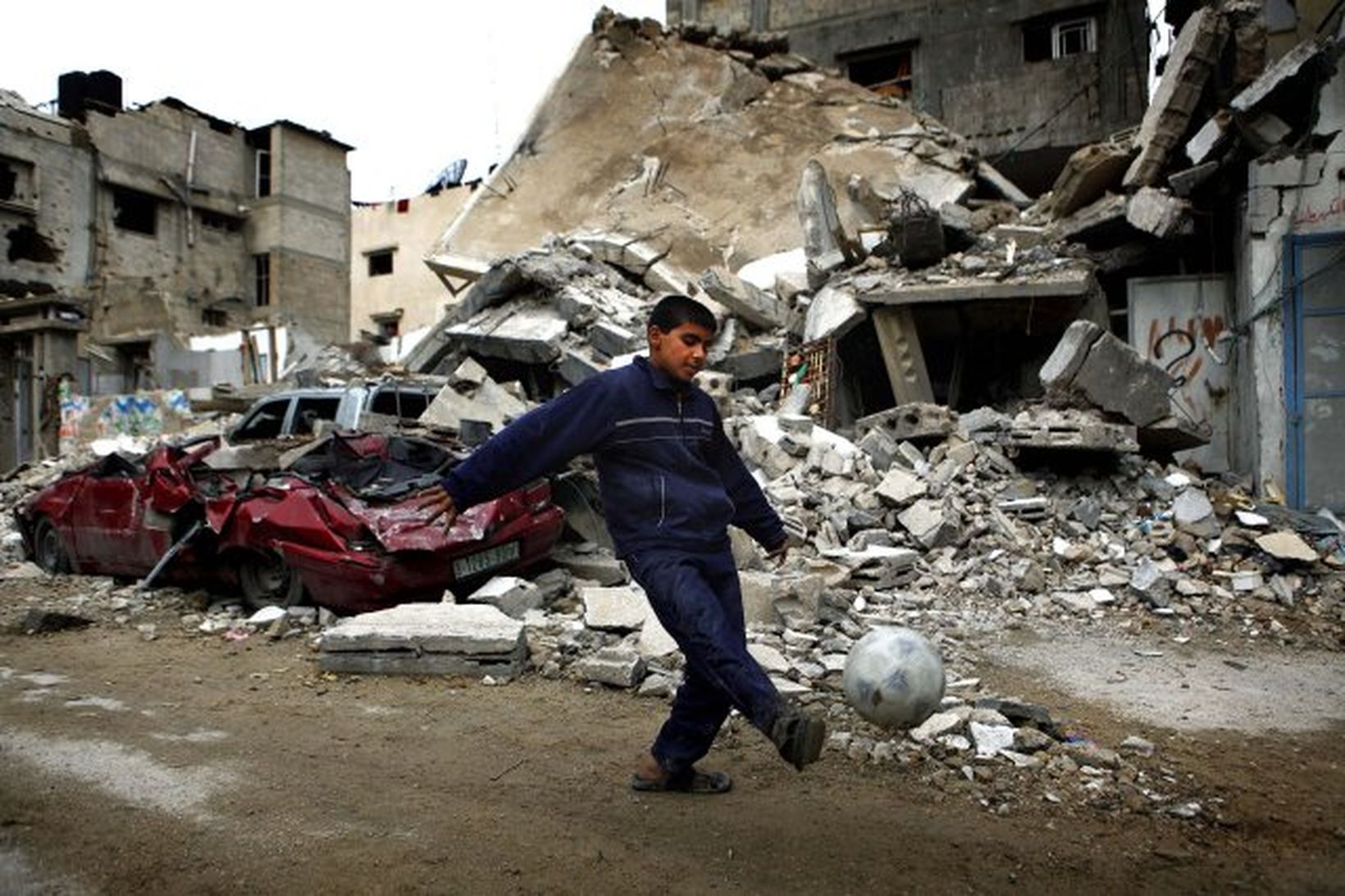 Palestínskur drengur að leik í rústum á Gaza