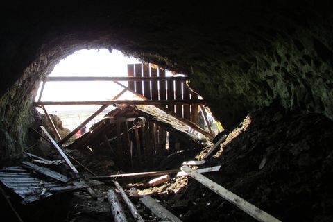 A photograph taken from the inside of the cave looking out. Two further floors lie deeper inside the cave.