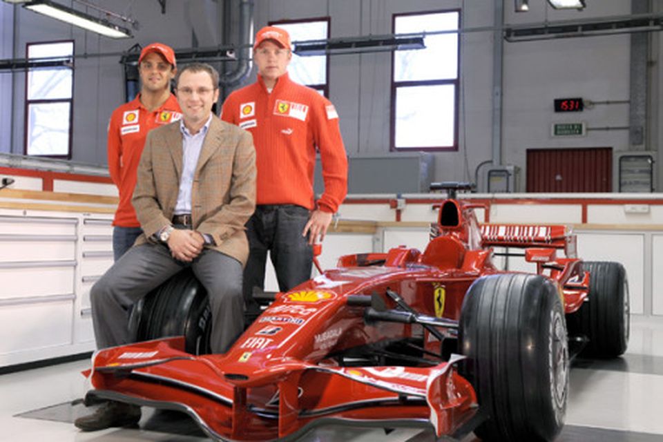 Räikkönen og Massa við 2008-bílinn í bílsmiðju Ferrari og á dekkinu situr liðsstjórinn Stefano Domenicali.