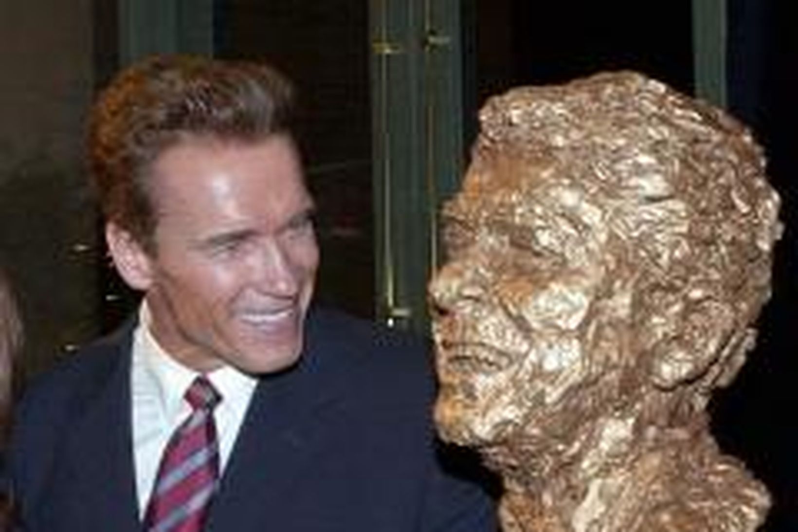 Arnold Schwarzenegger við hlið brjóstmyndar af Ronald Reagan, fyrrverandi forseta …