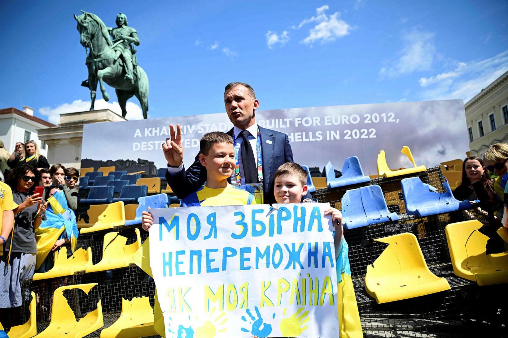 Andriy Shevchenko ásamt úkraínskum börnum framan við myndirnar af vellinum …