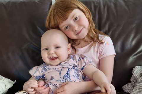 Katrín Una Sigurðardóttir with her little sister, Elvíra María, in her arms.