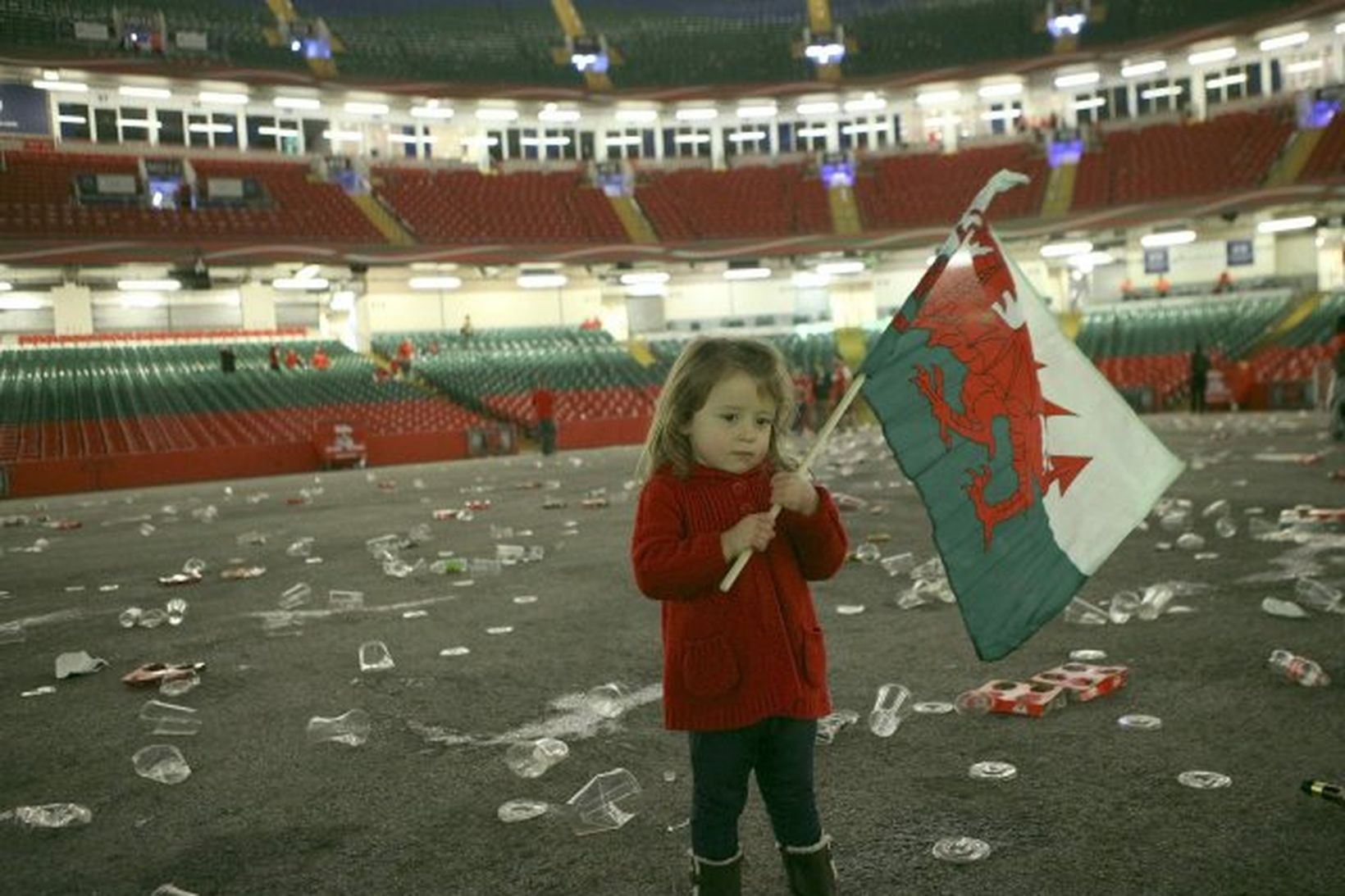 Lítil stelpa sveiflar velska þjóðfánanum á rúgbí leikvangi í Wales.