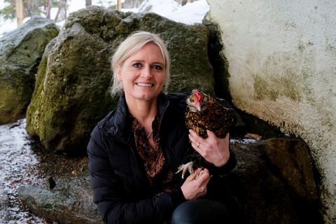 Sigrún Hulda Jónsdóttir, holding one of the hens.