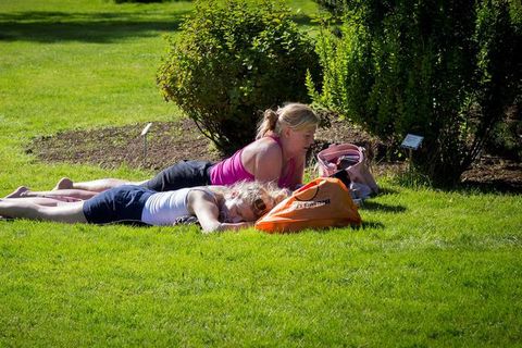 People enjoying the warm weather in Grasagarðurinn in Laugardalur park, Reykjavik.