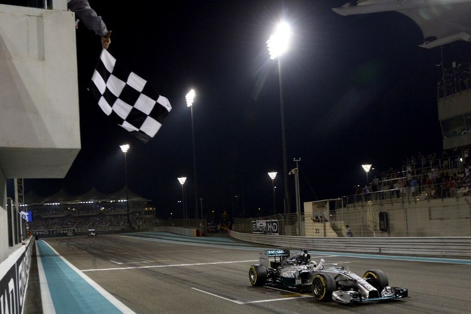 Köflótta flagginu veifað til Lewis Hamilton til marks um sigur hans í Abu Dhabi.