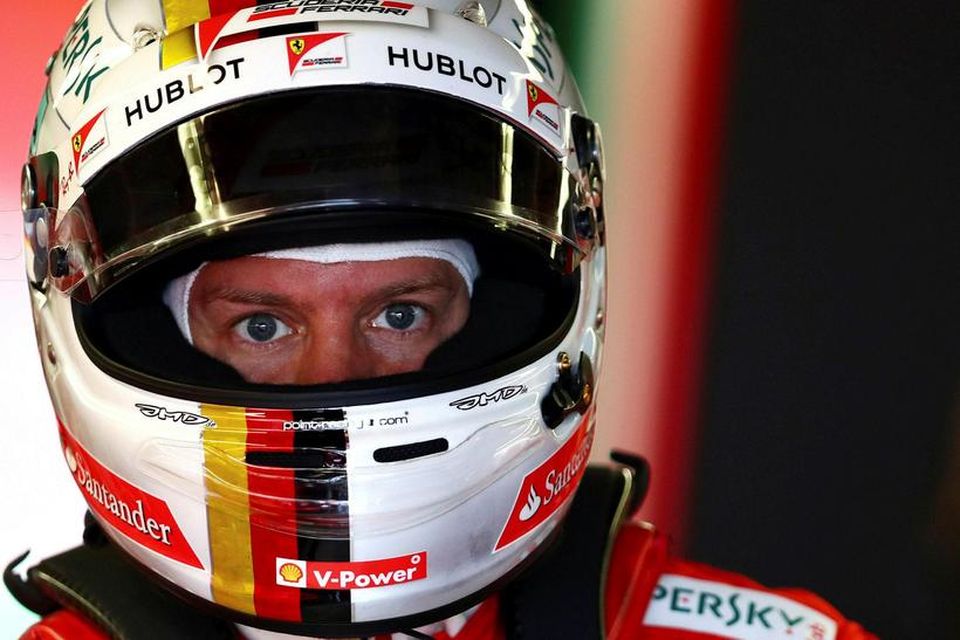 Sebastian Vettel undirbýr sig undir akstur í bílskúr Ferrari í Montreal.