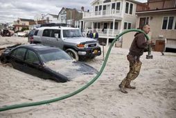 Bílar á kafi í sandi af völdum Sandy á Long Beach við New York.