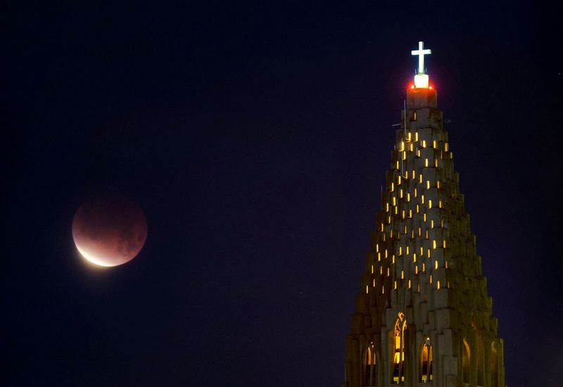 The moon, covered by a red hue. Hallgrímskirkja church is on the right.
