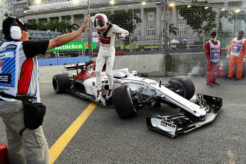 Charles Leclerc stekkur upp úr tjónuðum Sauberbílnum í Singapúr í morgun.