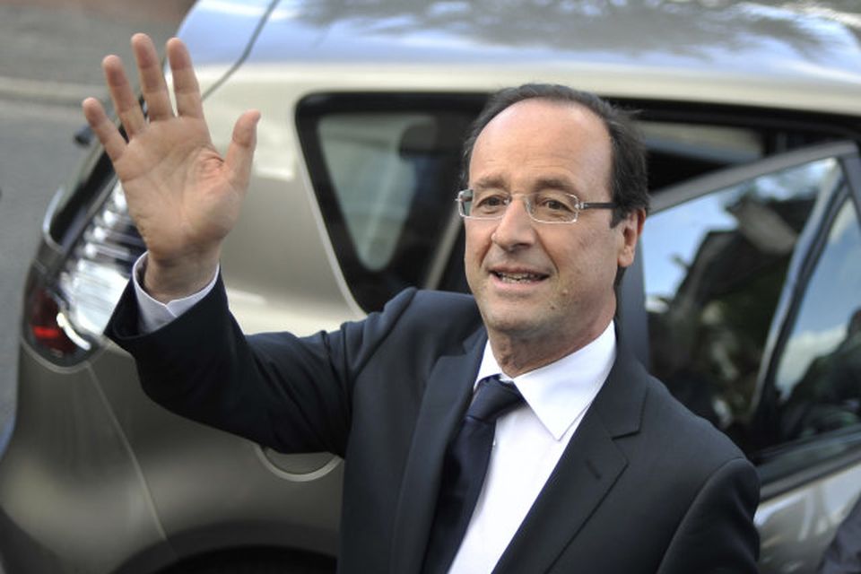 Francois Hollande veifar til kjósena eftir að hafa greitt atkvæði í dag.