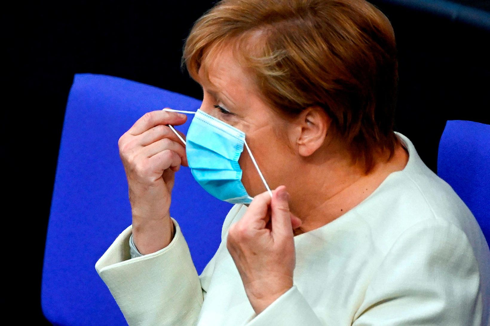 Kanslari Þýskalands, Angela Merkel, sést hér taka af sér grímuna …
