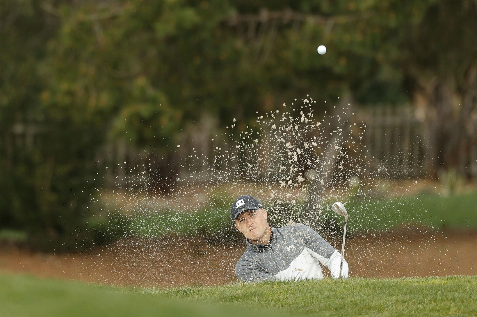 Jordan Spieth slær upp úr sandgryfju á Pebble Beach í …