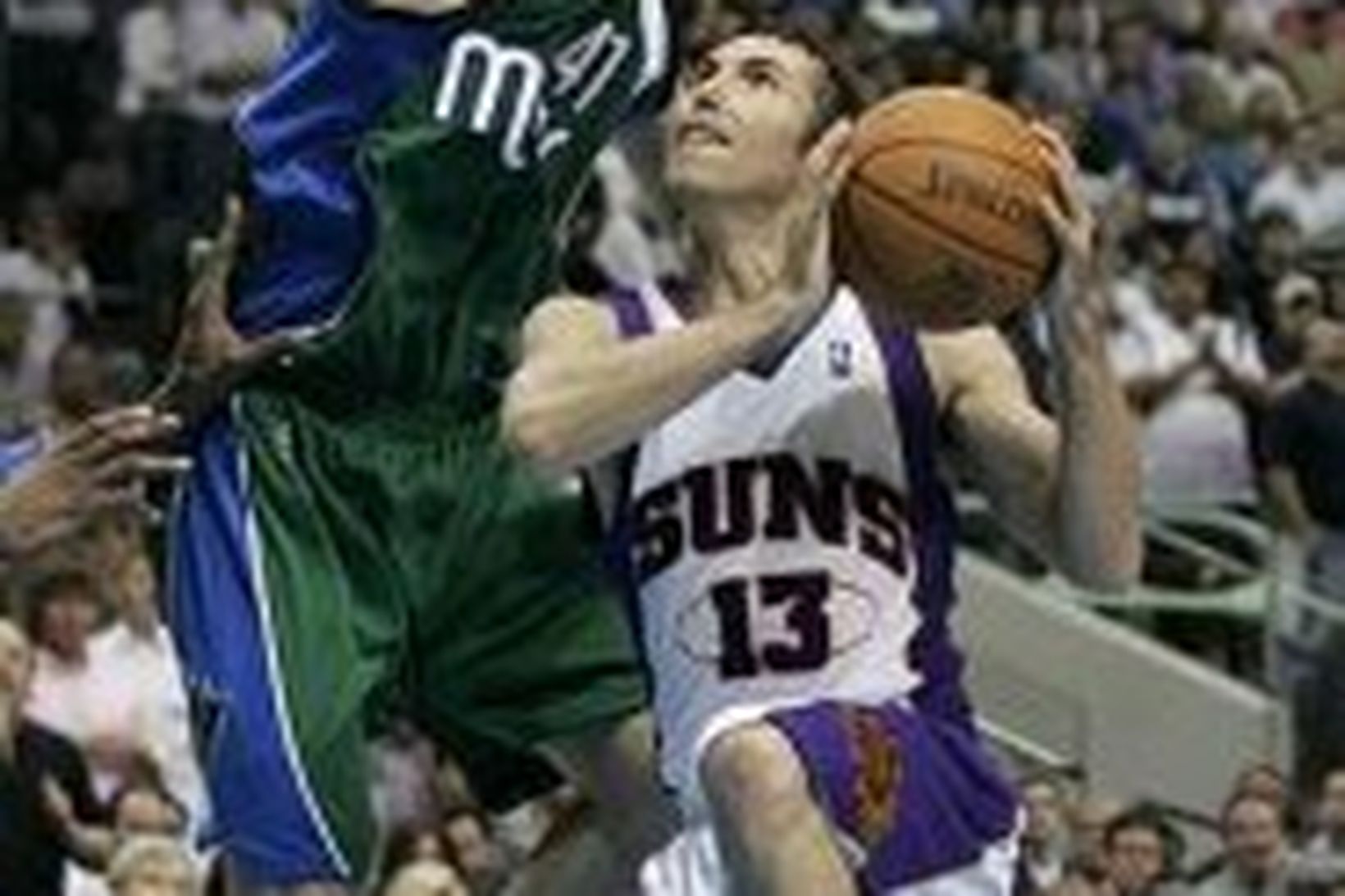 Steve Nash skorar framhjá Dirk Nowitzki.