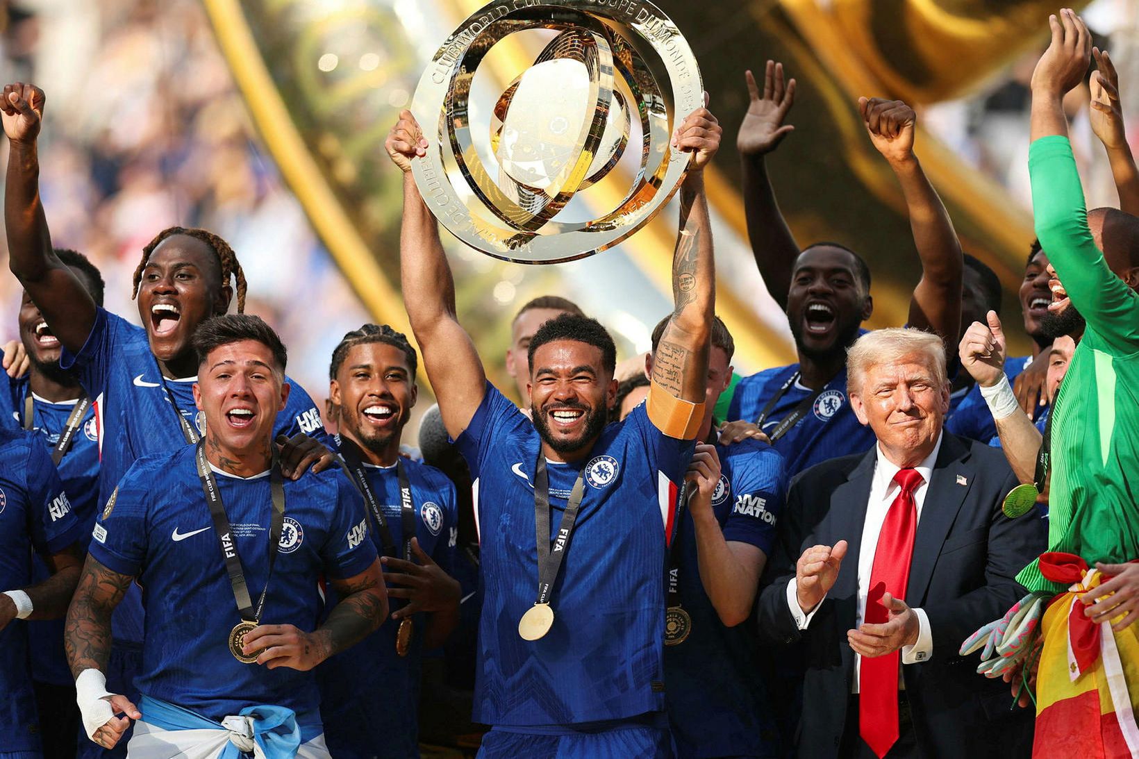 Donald Trump stendur við hlið fyrirliðans Reece James sem lyftir …