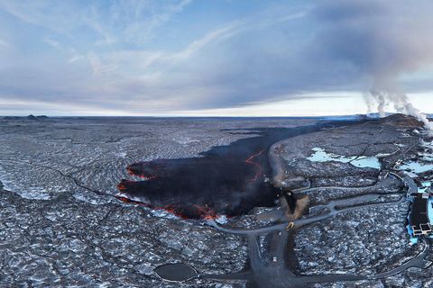 View across the Blue Lagoon, the new lava, the defense wall, and a natural threshold that directs the lava to the west. The photo was taken with a 360° camera and is therefore a wide image and the proportions are slightly distorted. Next in the photo is the road that crosses the dam, but you can see that an old lava field lies just beyond it and to the west. The lava field acts as a natural threshold and pushes the lava to the west.