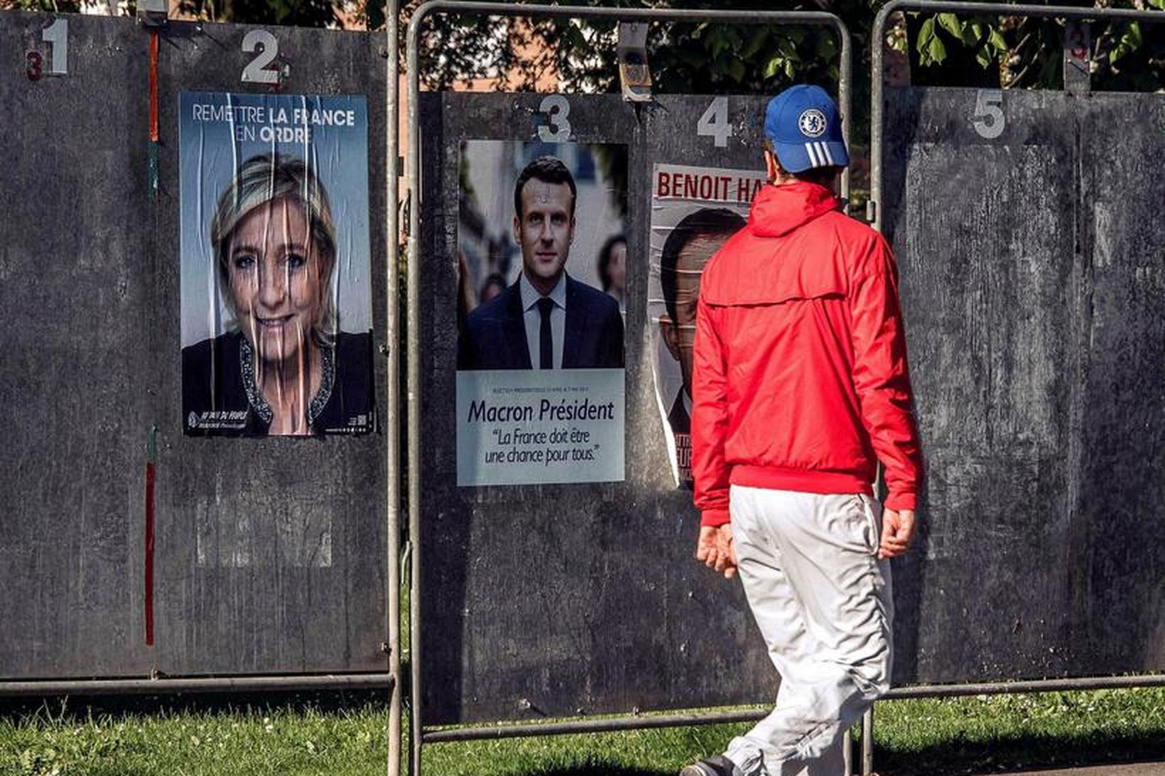 Franskur maður virðir fyrir sér veggspjöld Marine Le Pen og …