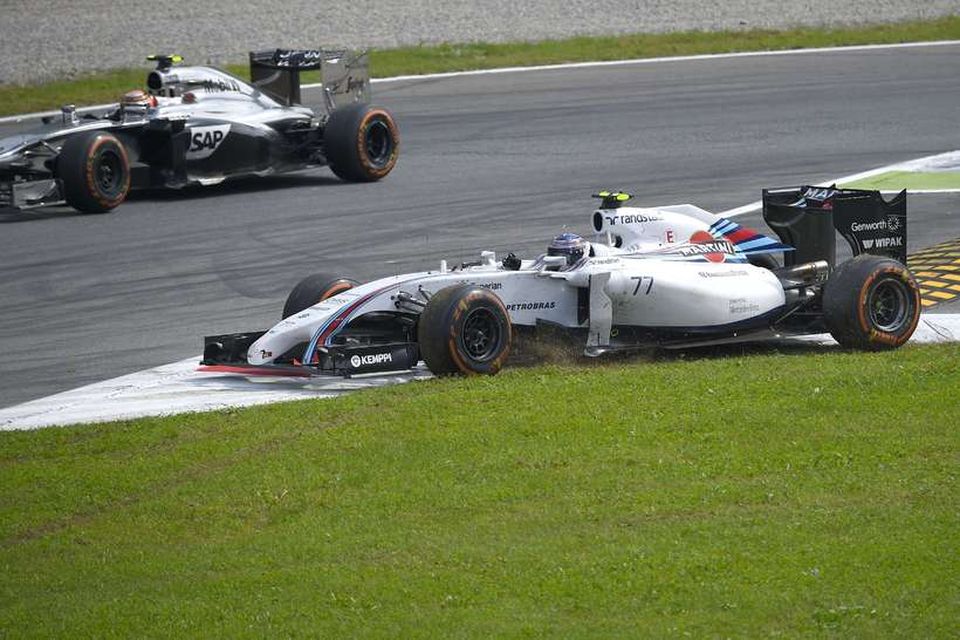 Valtteri Bottas varð að skera beygjuna eftir að Magnussen (fjær) knúði hann út úr brautinni.