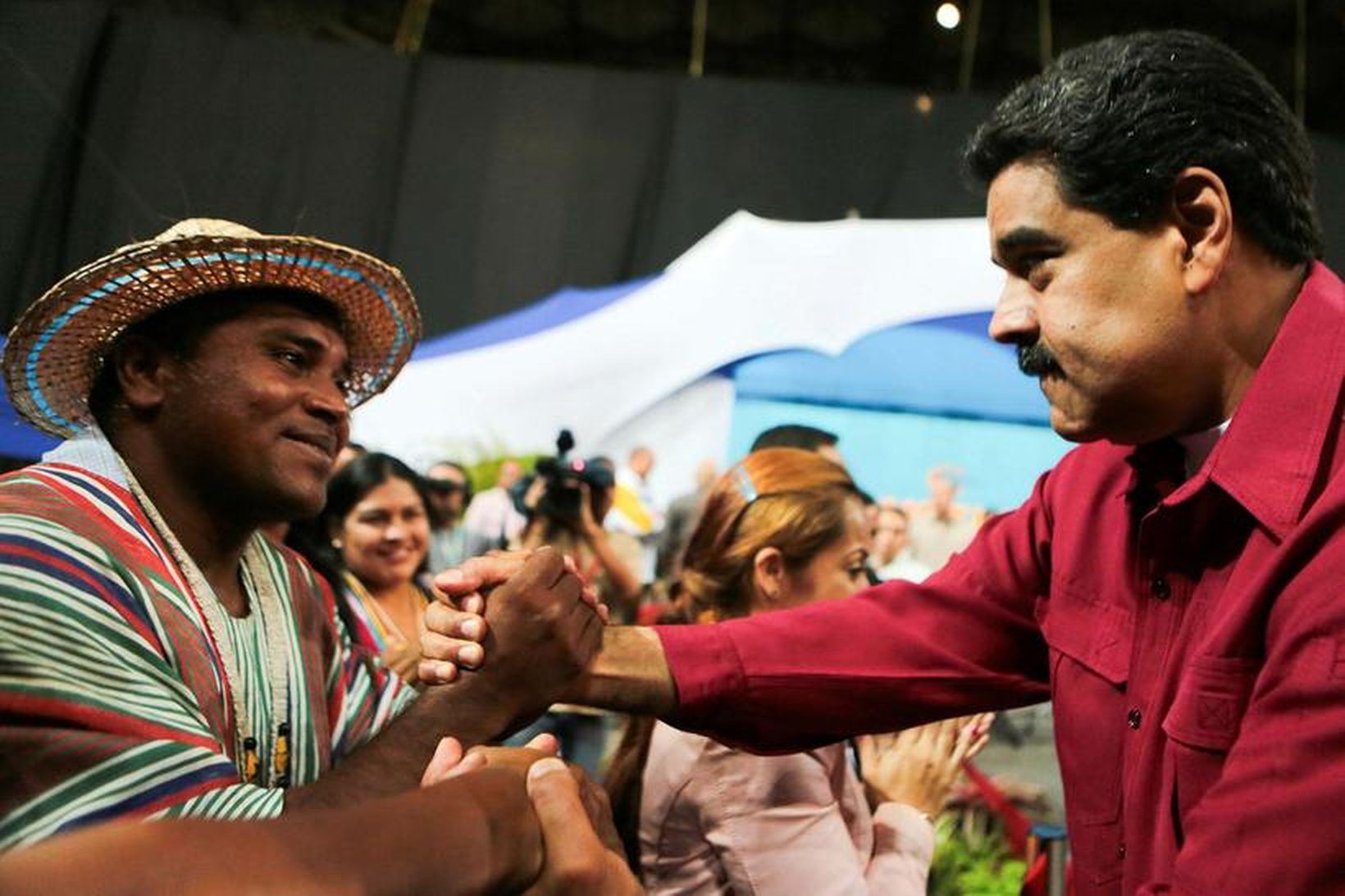 Nicolas Maduro tekur í hönd stuðningsmanns síns er kosningar til …