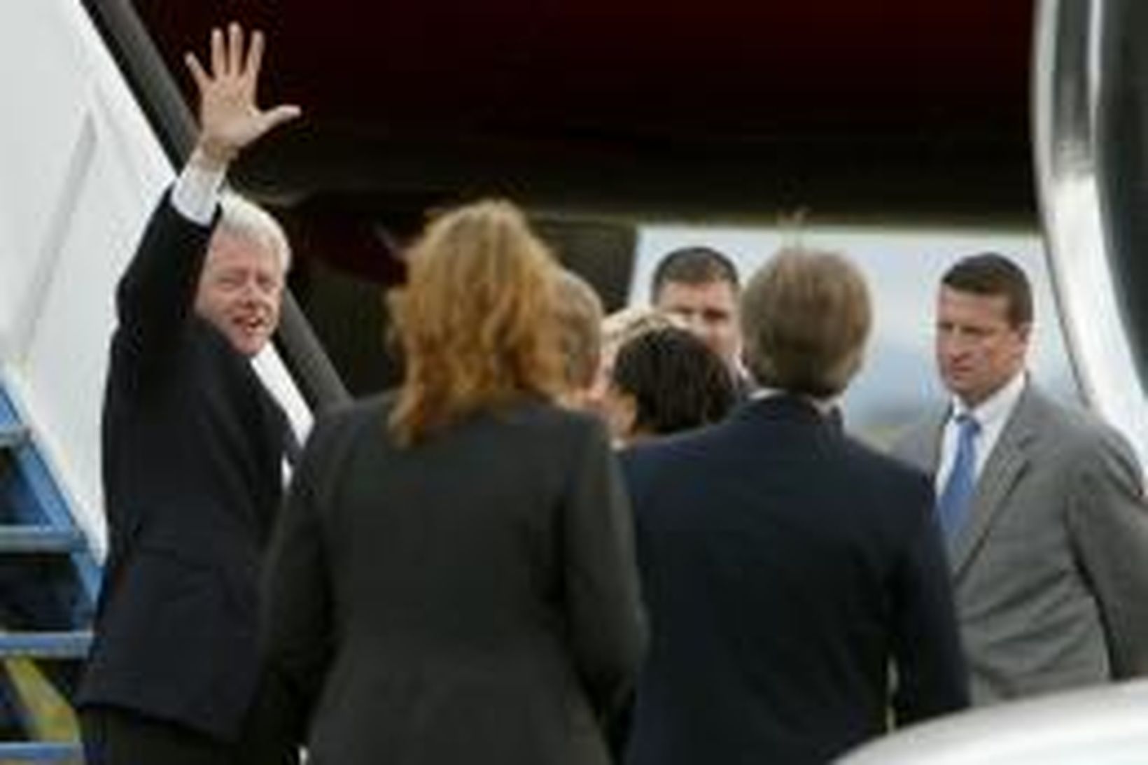 Bill Clinton veifar til viðstaddra áður en hann gengur um …