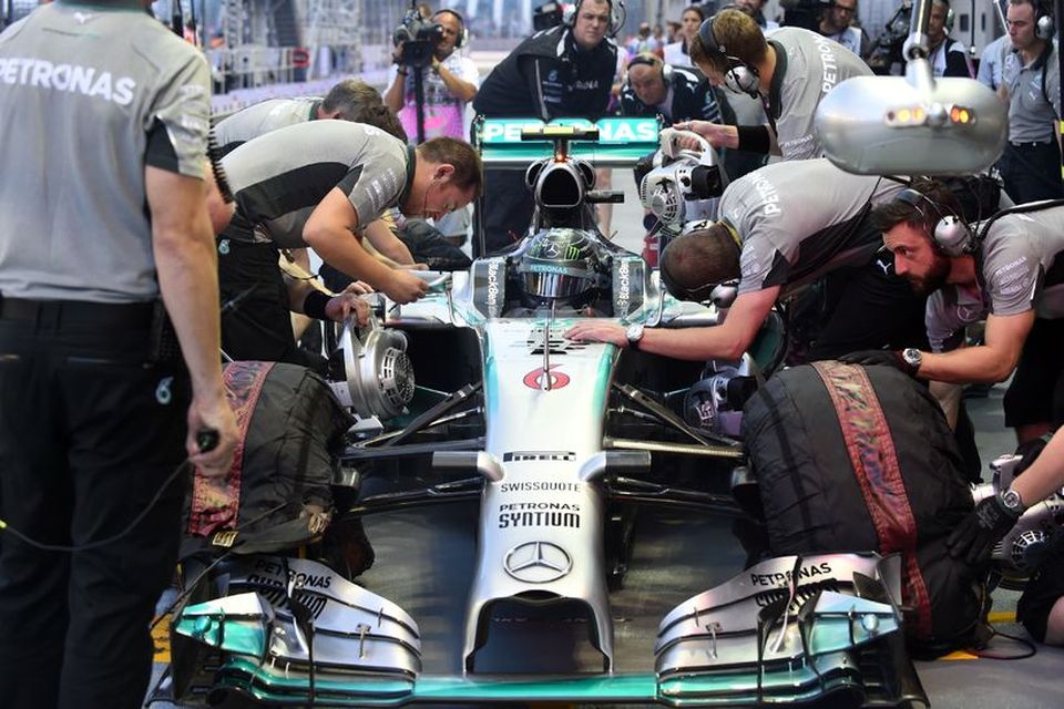 Tæknimenn Mercedes vinna í bíl Nico Rosberg milli aksturslota í Singapúr í dag.