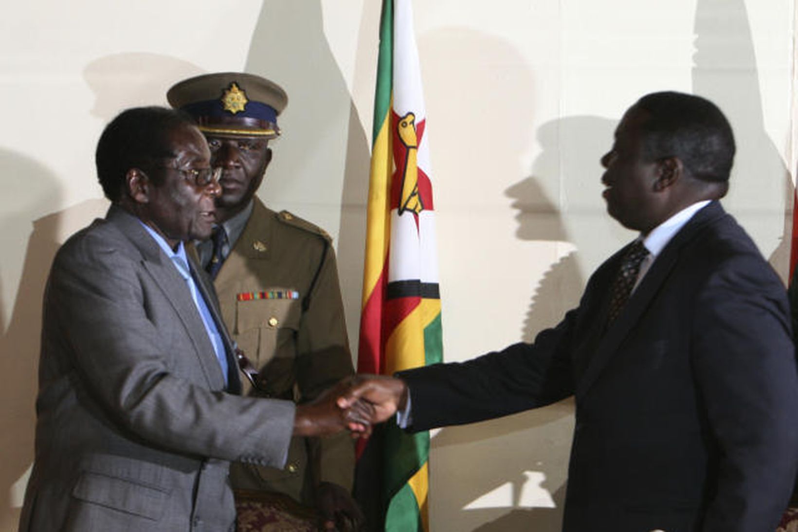 Morgan Tsvangirai og Robert Mugabe takast í hendur í í …